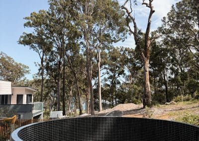 Round, tiled plunge pool in rural setting by Cove Pools, Newcastle